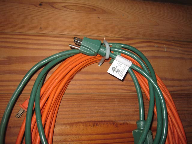 Hook holding extension cords on wood plank shed wall