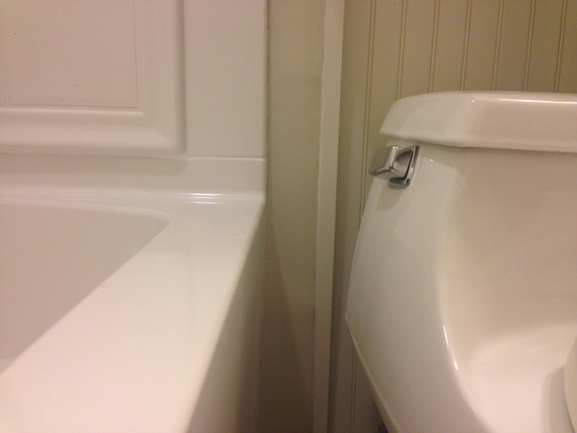 tan wall between bathtub and toilet complete drywall repair