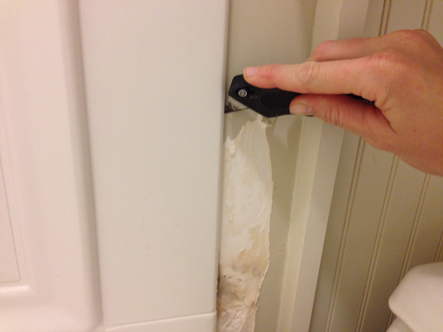utility knife scoring water damaged tan drywall