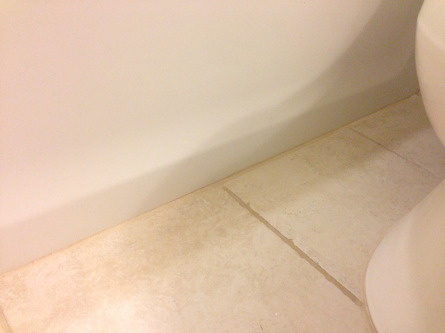 tan tile in bathroom against bathtub with linen colored grout repair finished