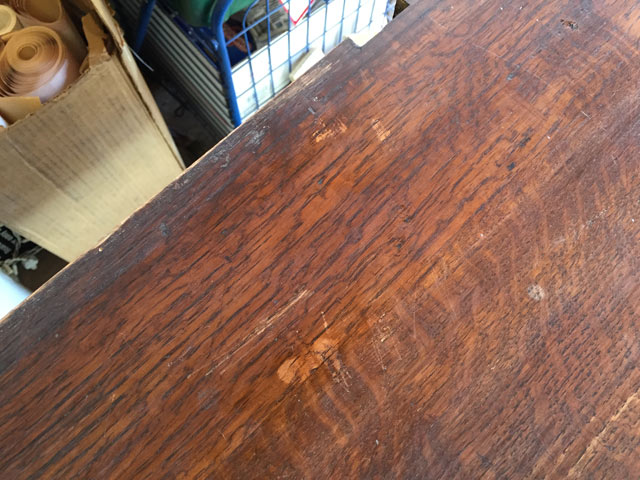 bare wood spot on stained wood furniture covered with a dab of wood stain