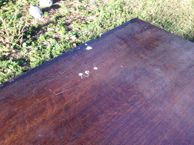 stained wood dresser top with two paint spills