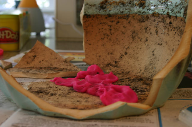 hot pink modeling clay holding broken planter pieces